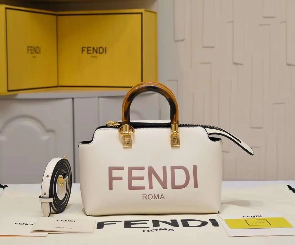 Fendi-Roma-Double-Handle-White-Bag Close-up of white Fendi Roma Double Handle mini bag with tortoiseshell handle, gold hardware, and detachable shoulder strap on a shelf with Fendi boxes.