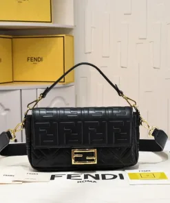 Close-up of the medium black Fendi Baguette bag, highlighting the 3D embossed FF motif and gold-finish FF clasp.