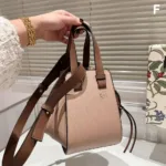 Tan leather Loewe Mini Puzzle Bag viewed from the side, emphasizing the precise cut geometric panels and cuboid shape.