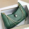 Bvlgari Serpenti Forever top handle bag in emerald green crocodile or python skin.