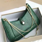 Bvlgari Serpenti Forever top handle bag in emerald green crocodile or python skin.