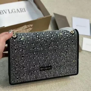 Bvlgari luxury shoulder bag, heavily embellished with crystals or rhinestones on a black background.