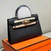 Mini ostrich leather handbag with gold detailing displayed upright