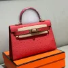 High-quality ostrich leather mini handbag with secure front closure