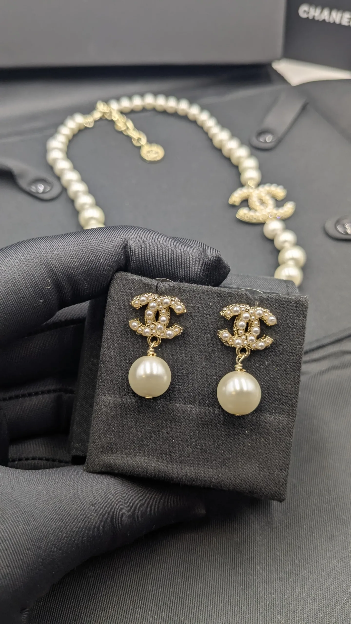 Luxury Faux Pearl & Gold-Tone CC Logo Jewelry Set Detailed view of a graduated pearl necklace and drop earrings set, showcasing the intricate rhinestone embellishment on the signature interlocking C logo.