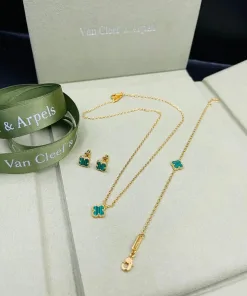 Gold-tone bracelet and necklace featuring clover design alongside earrings