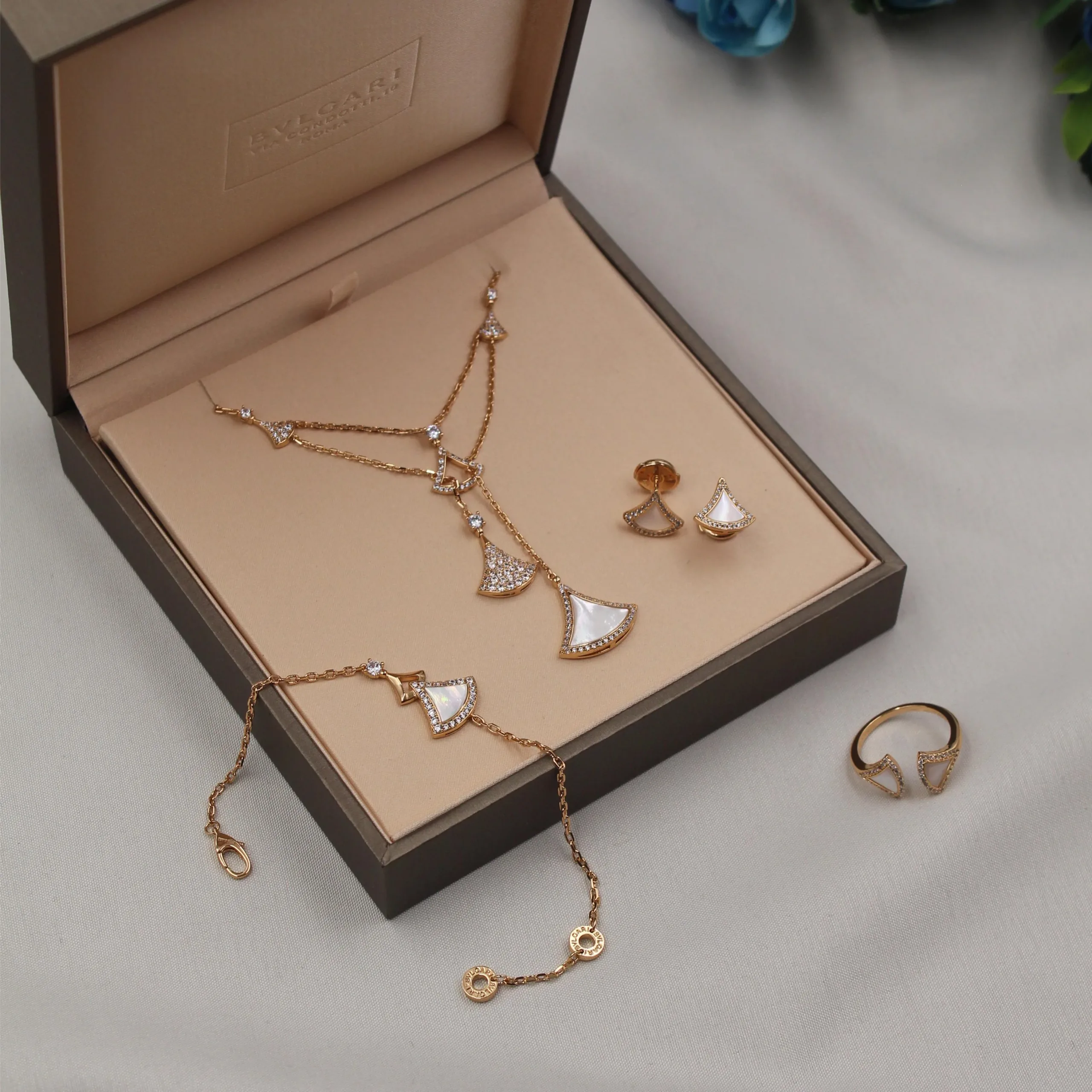 Timeless Classic Pearl Collar Necklace with Adjustable Chain Close-up on the necklace's adjustable lobster clasp and the varying sizes of the lustrous faux pearls, set against a dark, folded fabric background.