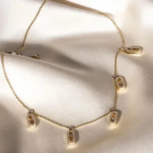 Detailed shot of the oval link stations on the plated necklace, highlighting the brilliance of the pavé-set cubic zirconia crystals.