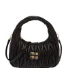 Black Miu Miu Mini Wander bag showing matelassé stitching and gold-tone logo lettering