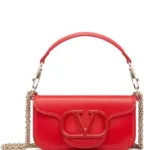 Red leather shoulder bag featuring gold chain strap and oversized logo plaque