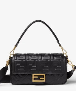 Close-up of the medium black Fendi Baguette bag, highlighting the 3D embossed FF motif and gold-finish FF clasp.