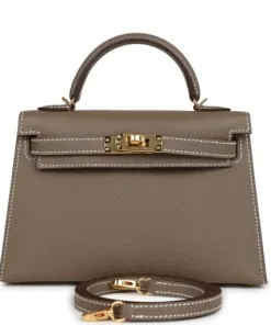 Compact leather handbag shown with box, dust bag and accessories