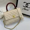 Side view of Chanel Coco Handle Medium handbag in white cream Caviar leather
