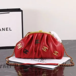 Red pleated leather handbag with gold chain strap and decorative metallic accents