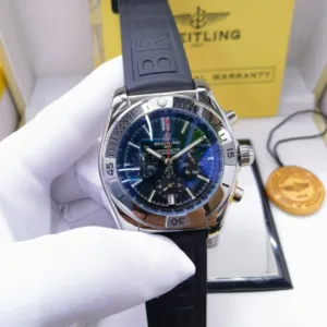 A stainless steel Breitling chronograph watch with a detailed blue/black dial, presented in its box with a warranty card and black rubber strap.