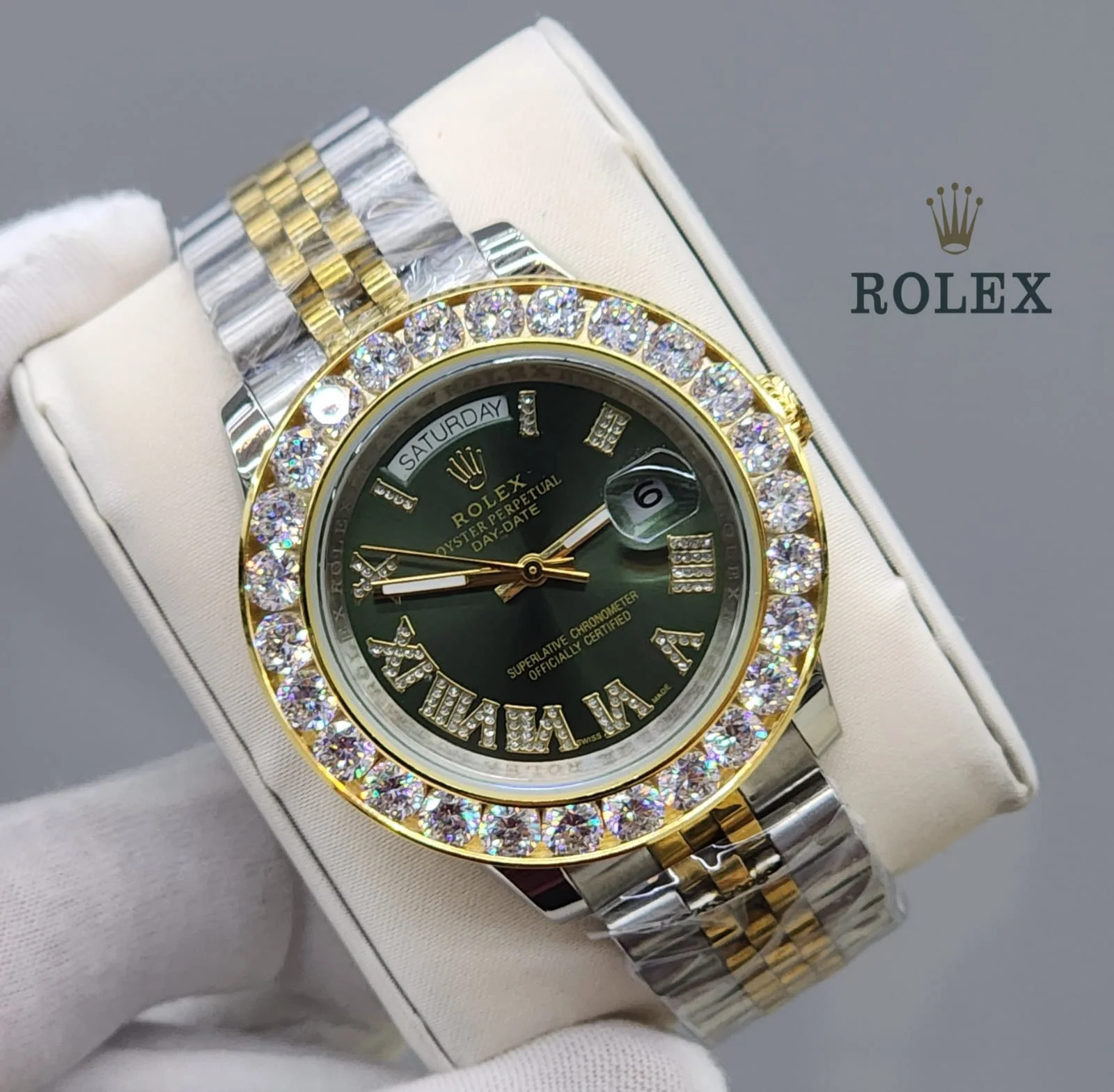 rolex-day-date-40-yellow-gold-green-diamond-dial Close-up of a yellow gold Rolex Day-Date 40 with a fluted bezel, featuring a green dial with diamond-set Roman numeral hour markers.
