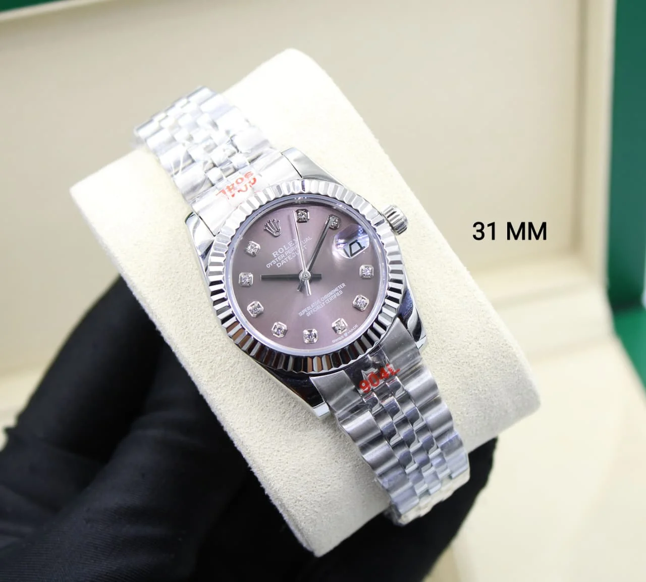 Rolex Datejust 31 Stainless Steel Jubilee Diamond Dial Watch Close-up shot of a 31mm ladies' Rolex Datejust watch on a cream cushion, featuring a stainless steel fluted bezel, Jubilee bracelet, and a purple/brown mother-of-pearl dial with ten diamond markers