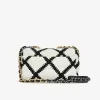 Close-up of black crochet stitching on Chanel 19 small white calfskin bag