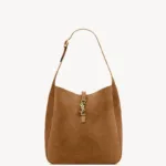 Tan suede hobo shoulder bag featuring the iconic large antique gold-toned YSL Cassandre logo on the front.