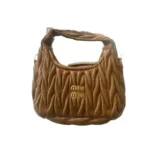 Side profile of elegant nappa leather hobo bag showing curved silhouette and premium craftsmanship