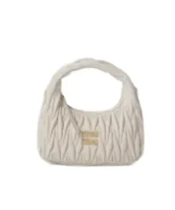 Close-up of gold-tone hardware and metal logo detailing on matelassé leather bag