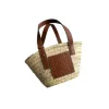 Full view of the artisan-made basket bag, showcasing the intricate woven raffia body and the smooth leather top handles.