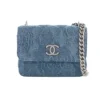 Chanel small flap bag in blue denim with subtle floral embossing and silver chain strap.