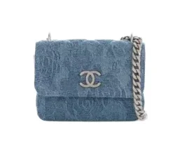 Chanel small flap bag in blue denim with subtle floral embossing and silver chain strap.