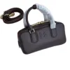Luxury compact Miu Miu handbag displayed with its detachable strap.