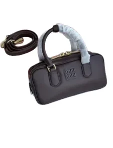 Luxury compact Miu Miu handbag displayed with its detachable strap.