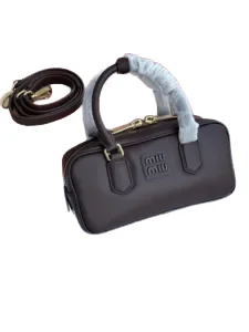 Luxury compact Miu Miu handbag displayed with its detachable strap.