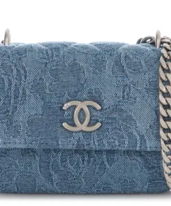 Chanel small flap bag in blue denim with subtle floral embossing and silver chain strap.