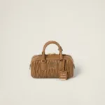 Front view of structured matelassé nappa leather top-handle bag with detailed texture and designer logo