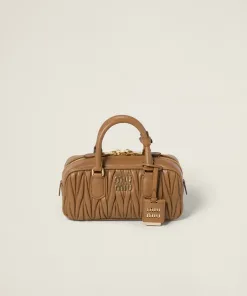 Front view of structured matelassé nappa leather top-handle bag with detailed texture and designer logo