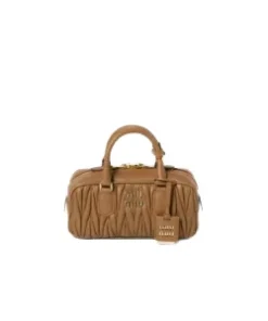 Front view of structured matelassé nappa leather top-handle bag with detailed texture and designer logo