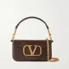 Detail of the convertible strap system on the Valentino leather bag, showing the top leather shoulder strap and the long detachable gold chain strap