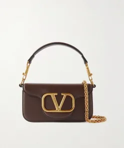 Detail of the convertible strap system on the Valentino leather bag, showing the top leather shoulder strap and the long detachable gold chain strap