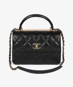 Small quilted Chanel bag in black leather with gold hardware and top handle.
