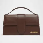 Close-up of Jacquemus handbag stitching and gold branding.