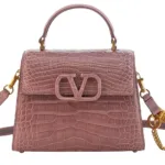 Close-up shot of the textured exotic leather on the Valentino top handle bag, highlighting the structured design and flap closure.