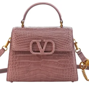 Close-up shot of the textured exotic leather on the Valentino top handle bag, highlighting the structured design and flap closure.