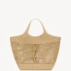 Hand-embroidered natural raffia ICARE maxi shopping bag with oversized sculptured Cassandre design and bronze-toned hardware.
