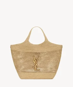 Hand-embroidered natural raffia ICARE maxi shopping bag with oversized sculptured Cassandre design and bronze-toned hardware.