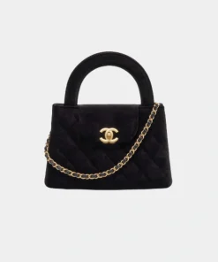 Chanel quilted handbag featuring a top handle, chain strap, and front clasp