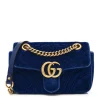 Gucci GG Marmont Velvet Mini Bag in navy blue chevron velvet, highlighted by antique gold GG logo plaque and sliding chain strap.