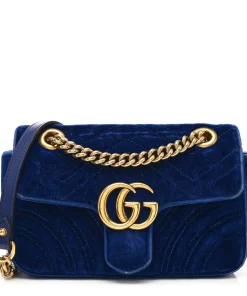 Gucci GG Marmont Velvet Mini Bag in navy blue chevron velvet, highlighted by antique gold GG logo plaque and sliding chain strap.