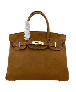 Side angle of Hermès Birkin 25 in camel brown leather, highlighting elegant curves and shape