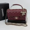 Burgundy Chanel mini quilted leather flap bag with top handle and chain strap
