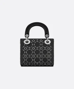Elegant black Dior Mini Lady Dior bag with crystal embellishments, top handles, and detachable strap