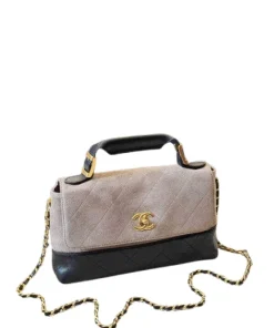 Close-up of brushed gold CC turn-lock on Chanel brown suede and black leather bag